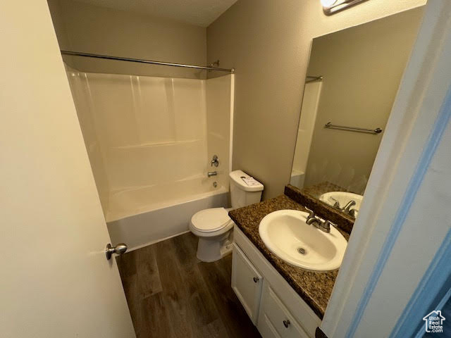 Full bathroom featuring toilet, shower / bathing tub combination, vanity, and hardwood / wood-style floors
