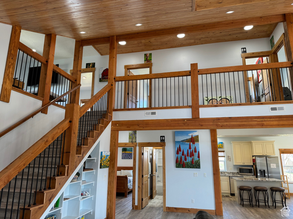 Staircase featuring wood ceiling and light hardwood / wood-style flooring
