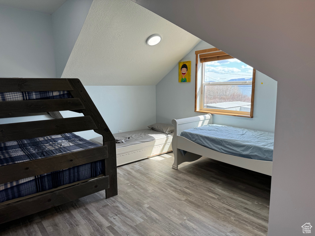 Bedroom featuring wood-type flooring and lofted ceiling