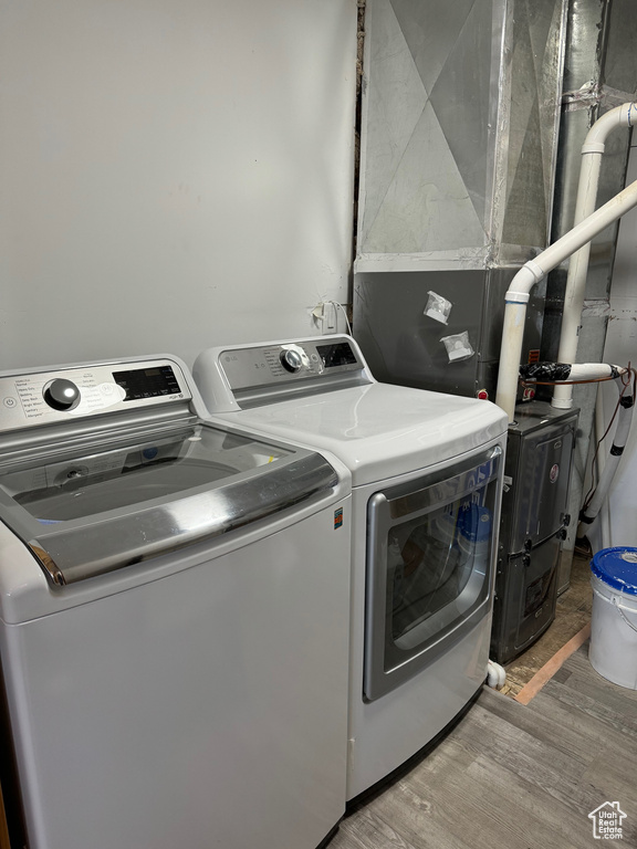 Laundry area with light hardwood / wood-style floors and washer and dryer