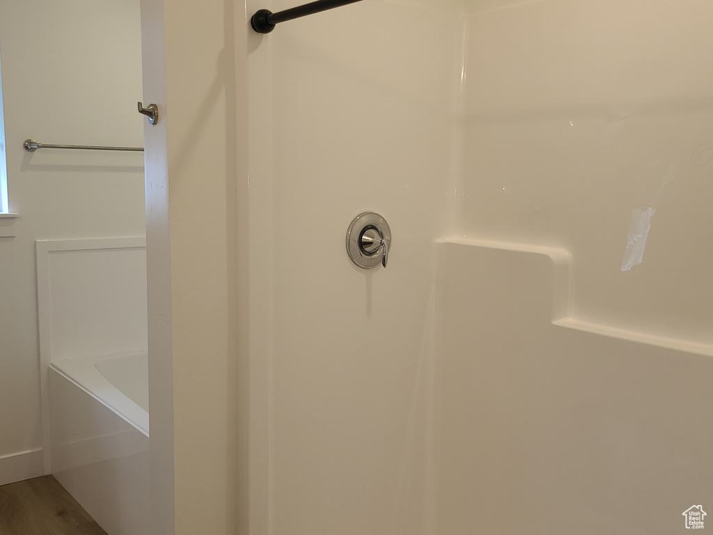 Room details with walk in shower and hardwood / wood-style flooring