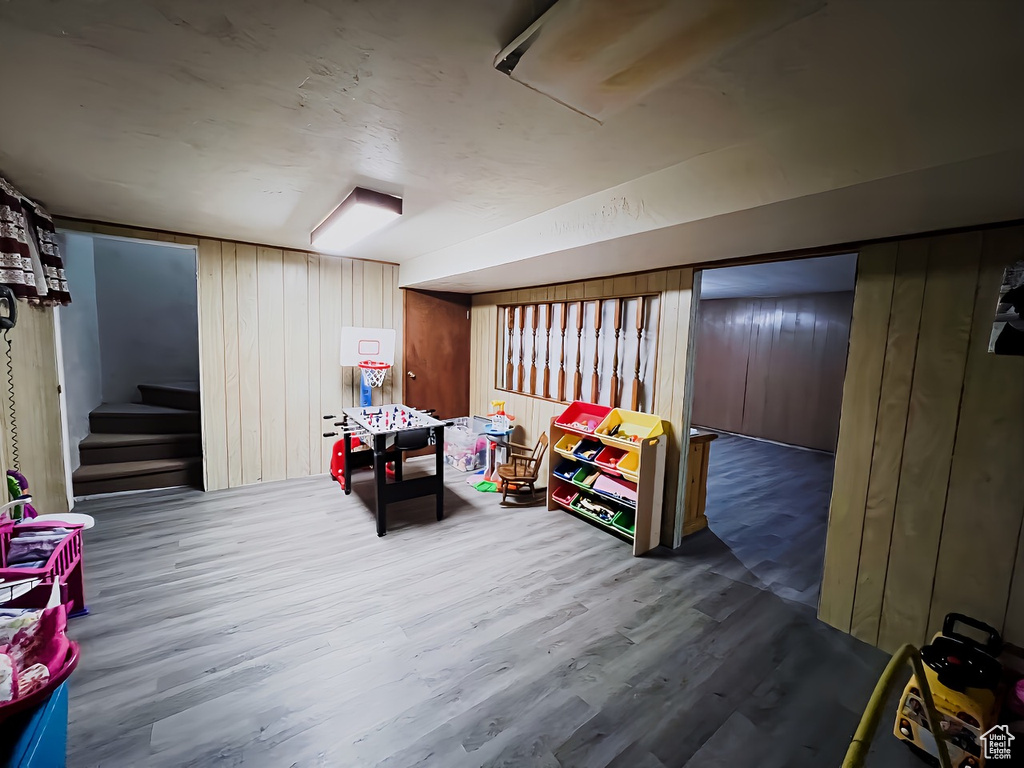 Basement with wooden walls and hardwood / wood-style floors