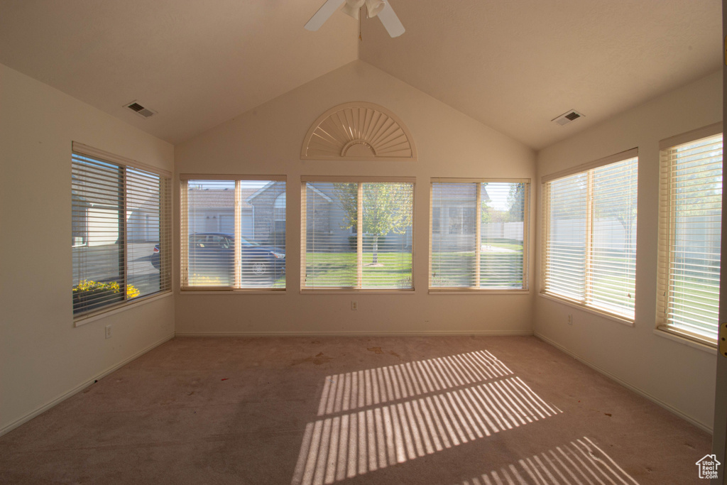 Unfurnished sunroom with ceiling fan and vaulted ceiling