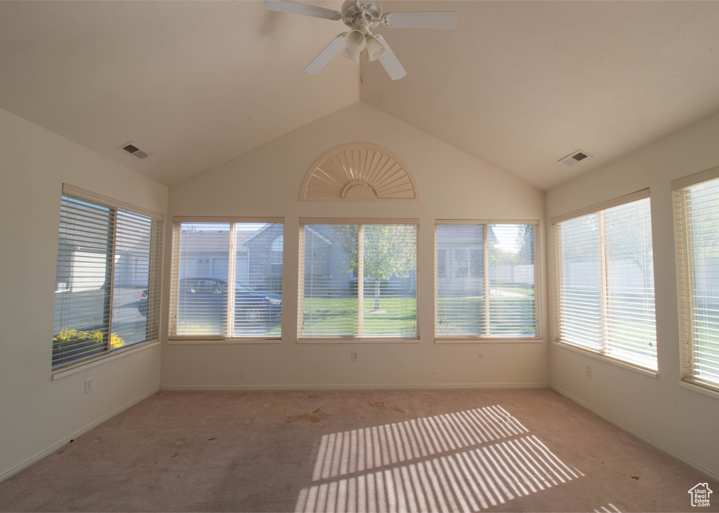 Unfurnished sunroom featuring ceiling fan and lofted ceiling