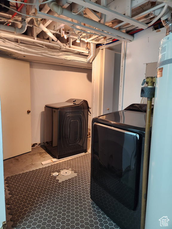 Clothes washing area with tile flooring, independent washer and dryer, and gas water heater