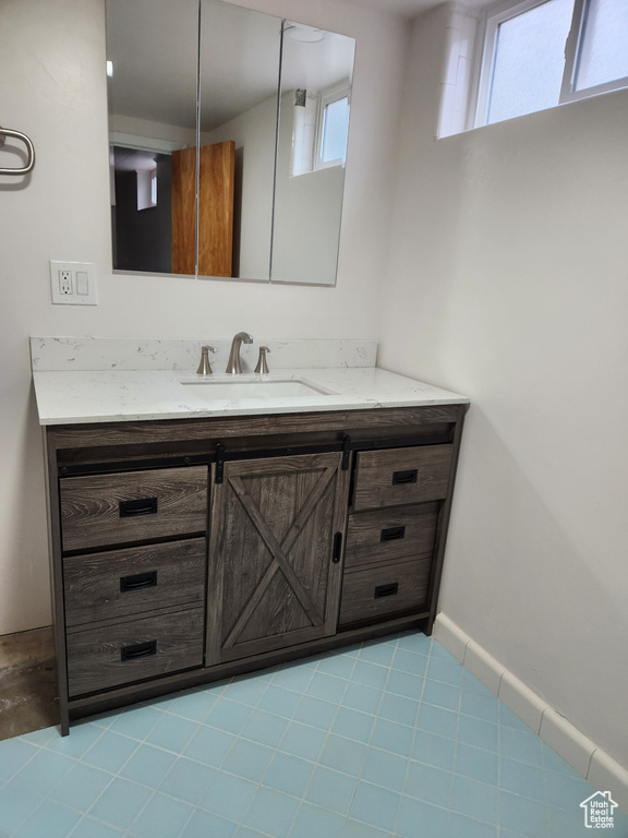 Bathroom featuring tile flooring and vanity with extensive cabinet space