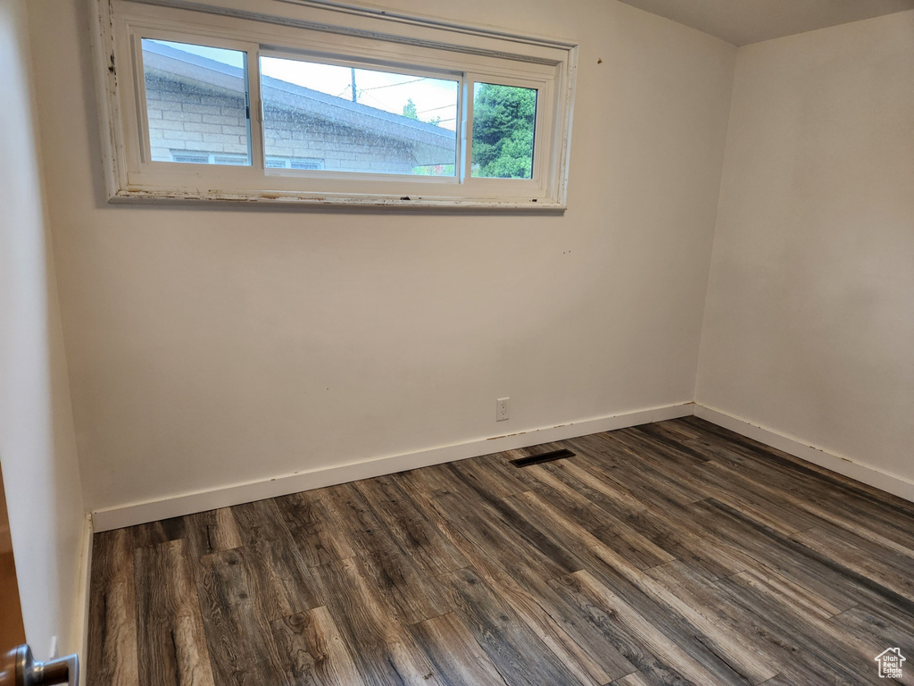 Empty room with dark hardwood / wood-style flooring