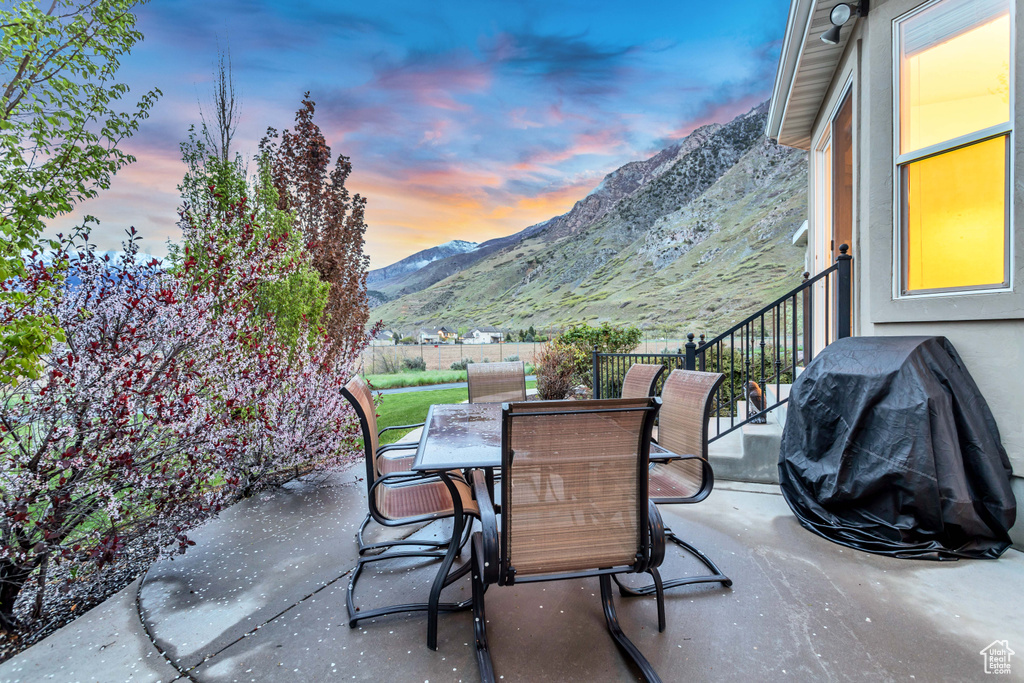Patio terrace at dusk with a mountain view and a grill