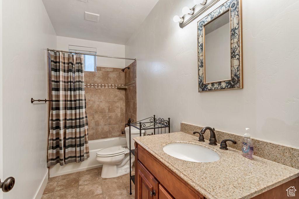 Full bathroom with toilet, tile floors, shower / bathtub combination with curtain, and vanity with extensive cabinet space