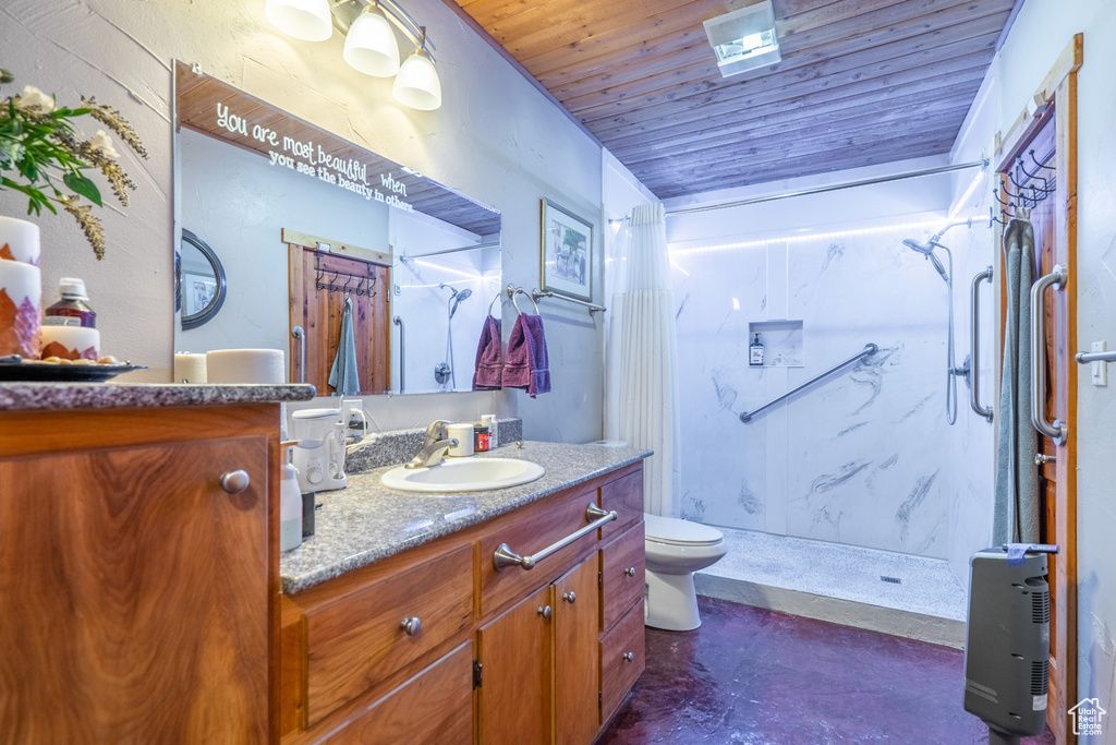 Bathroom featuring wooden ceiling, toilet, vanity with extensive cabinet space, and walk in shower