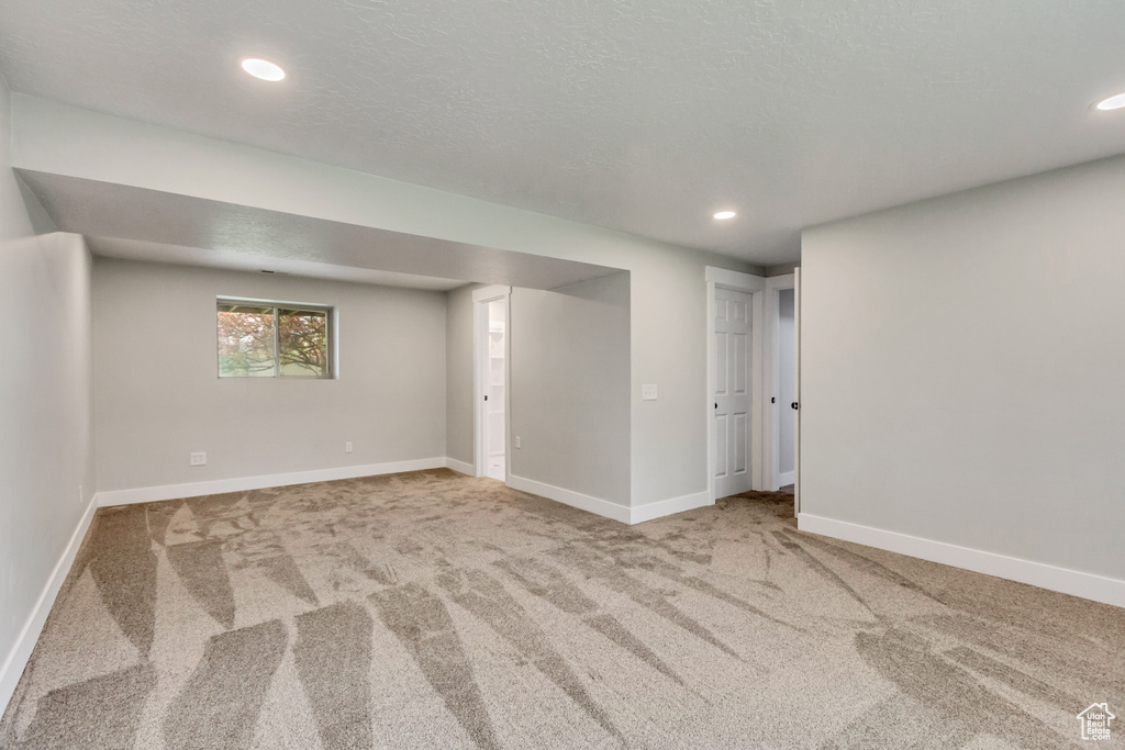 Basement with carpet floors and a textured ceiling