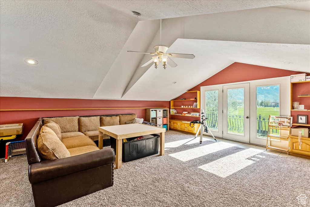 Playroom with ceiling fan, vaulted ceiling, carpet, and a textured ceiling