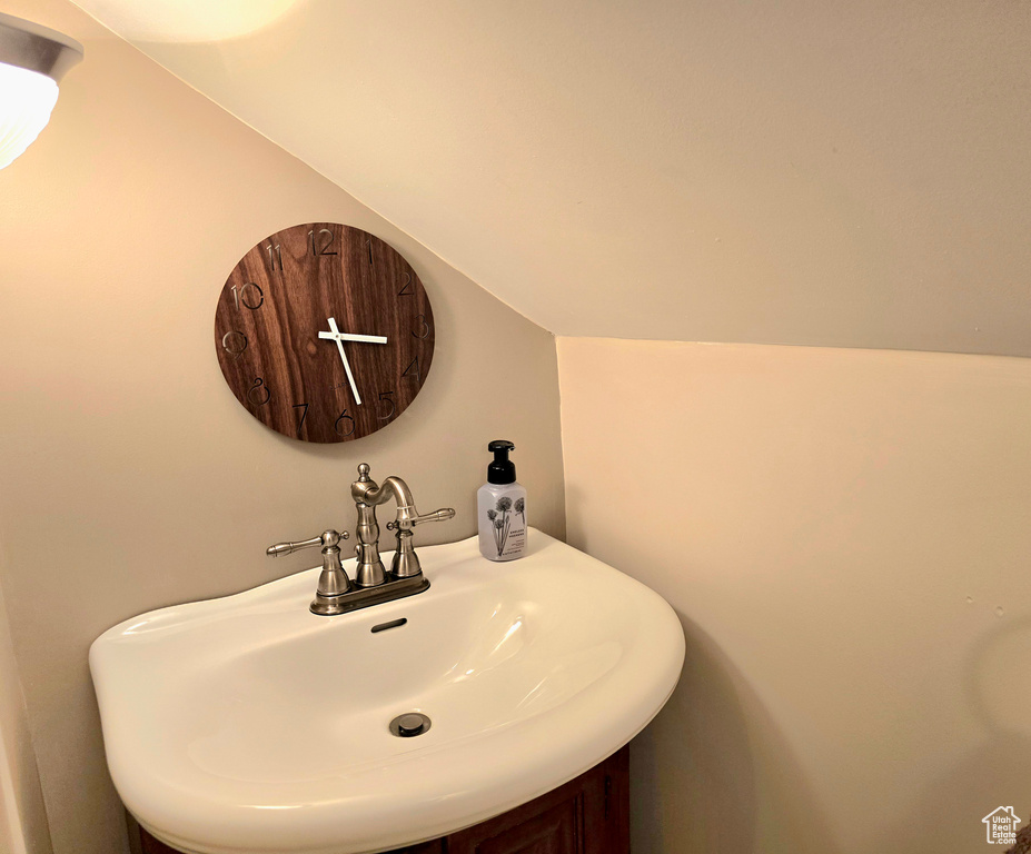 Bathroom featuring vaulted ceiling and vanity
