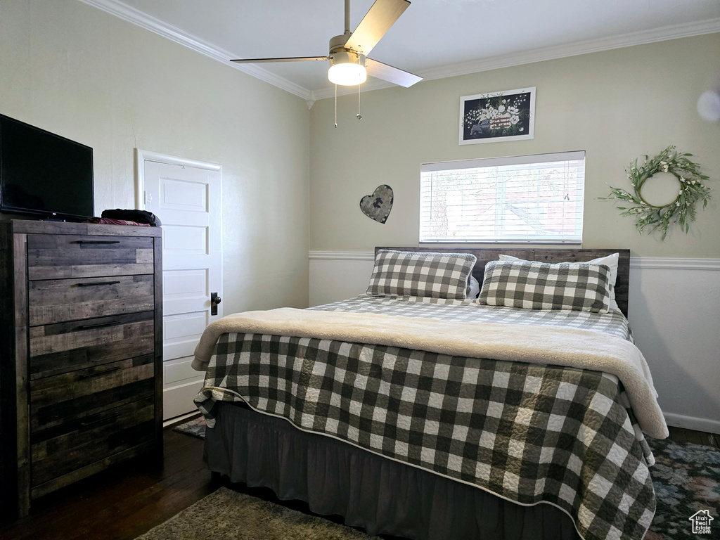 Bedroom featuring ceiling fan, dark hardwood / wood-style flooring, and ornamental molding