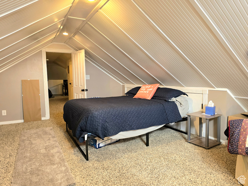 Bedroom featuring carpet floors and vaulted ceiling