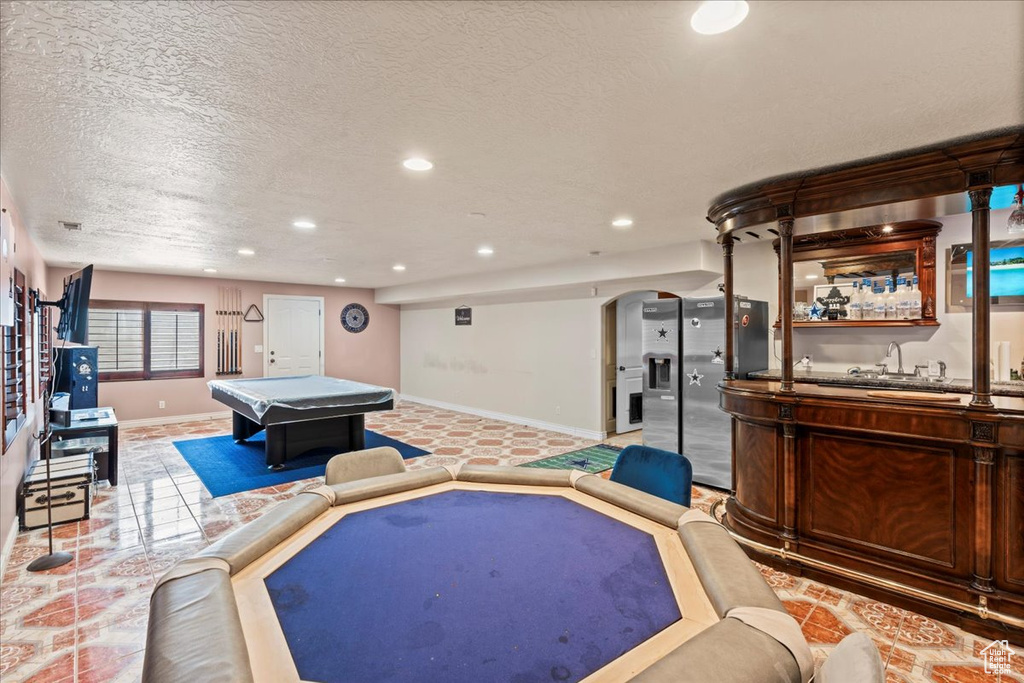Recreation room featuring light tile flooring, a textured ceiling, and billiards