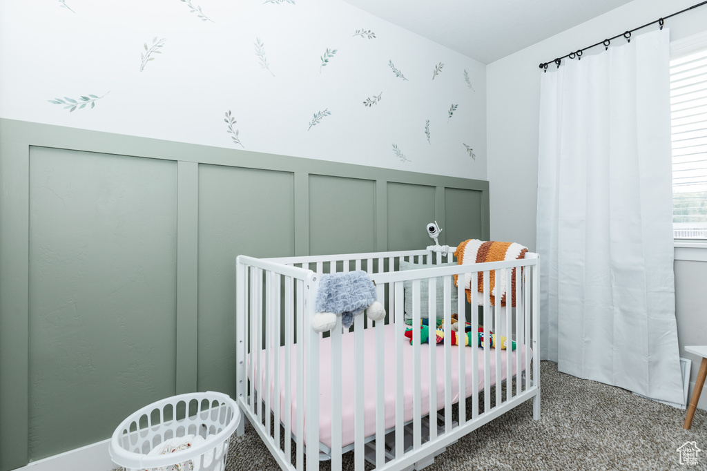 Bedroom featuring carpet flooring and a nursery area
