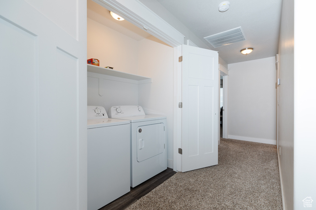 Laundry area with dark carpet and washing machine and clothes dryer