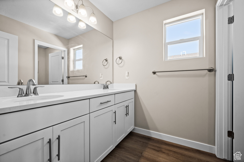 Bathroom with double vanity and hardwood / wood-style flooring