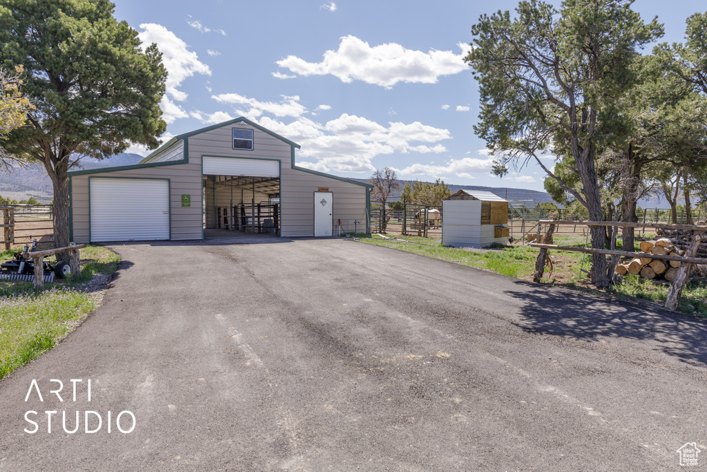 View of front of home with a garage and a storage unit