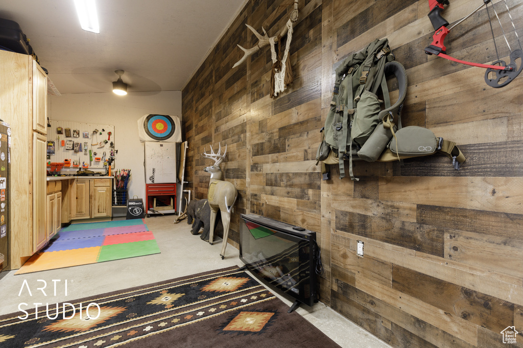 Interior space featuring wood walls, ceiling fan, and a workshop area