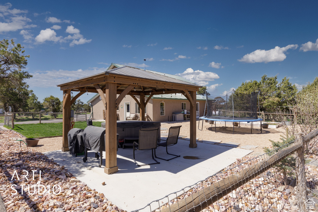 View of patio featuring a trampoline and a gazebo