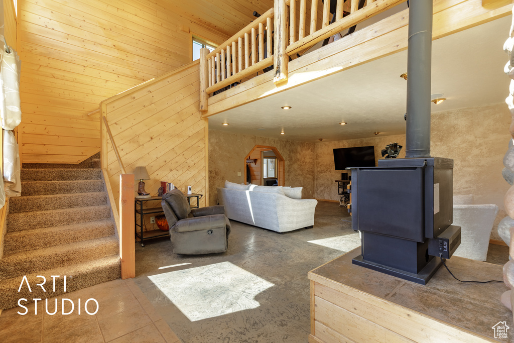 Tiled living room with wood walls and a wood stove