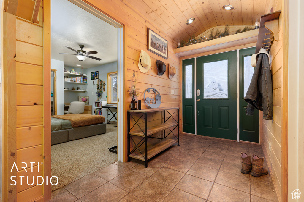 Carpeted entrance foyer with wooden ceiling, plenty of natural light, ceiling fan, and vaulted ceiling