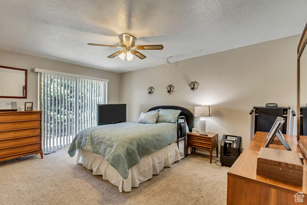 Bedroom featuring ceiling fan, carpet flooring, and access to outside