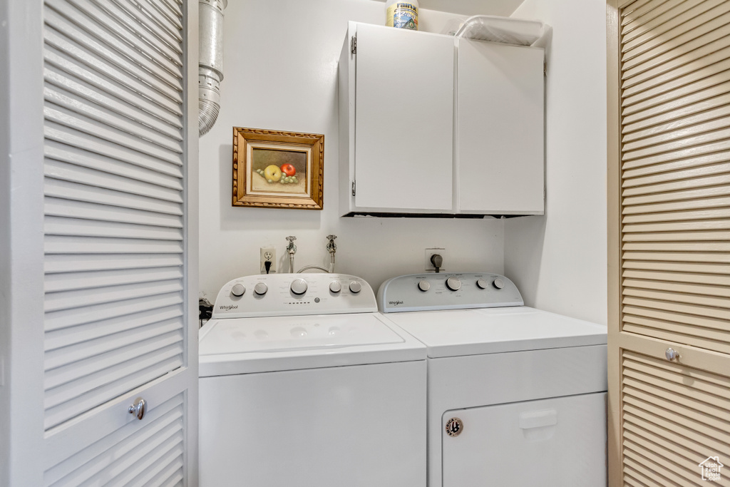 Clothes washing area featuring cabinets, washing machine and dryer, and electric dryer hookup