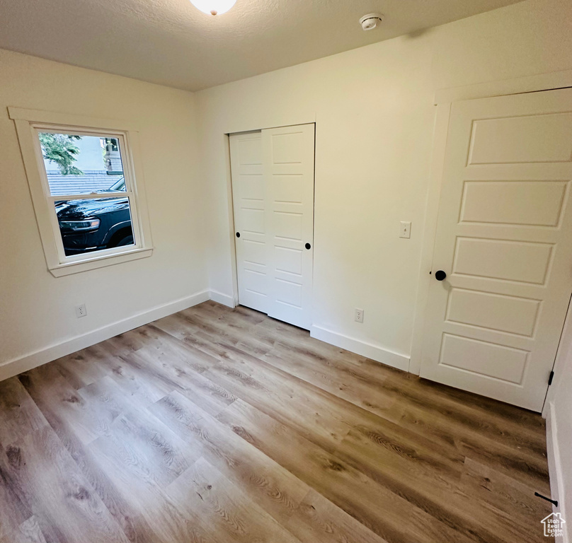 Unfurnished bedroom featuring hardwood / wood-style floors and a closet