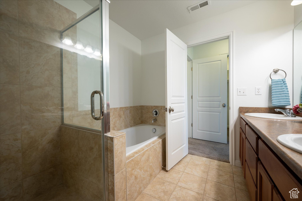 Bathroom featuring tile floors, separate shower and tub, and double sink vanity