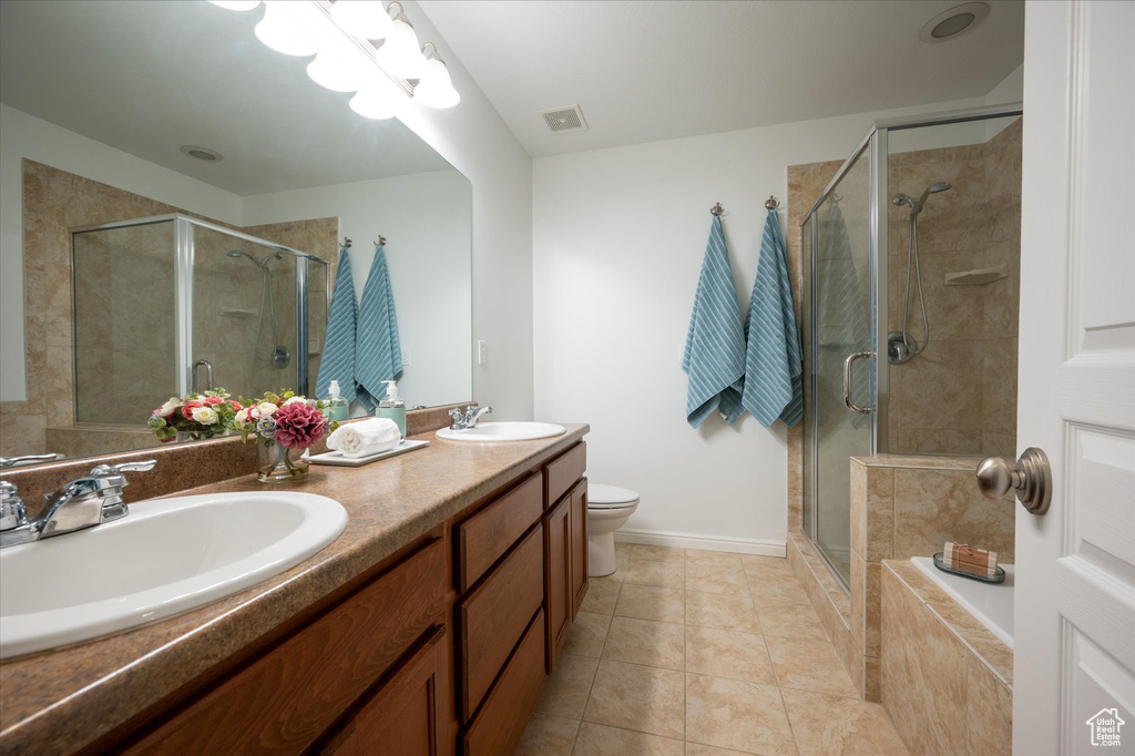 Full bathroom with independent shower and bath, large vanity, toilet, tile flooring, and double sink