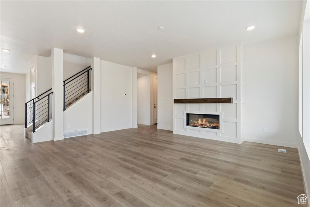 Unfurnished living room featuring light hardwood / wood-style flooring and a fireplace