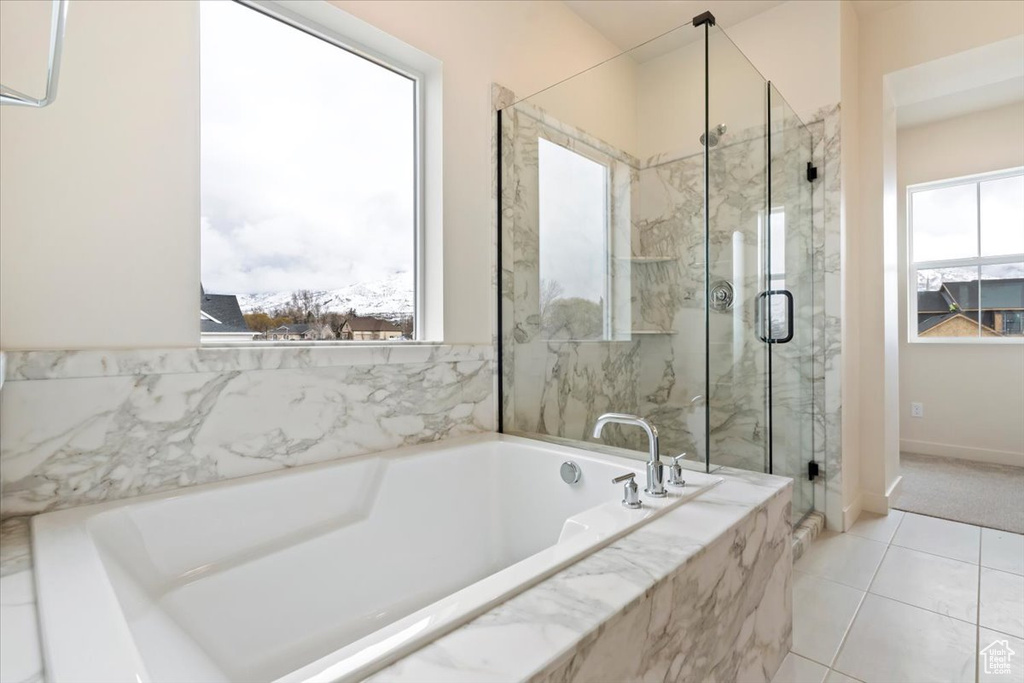 Bathroom featuring tile floors and shower with separate bathtub