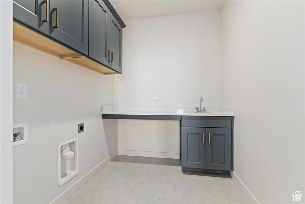 Washroom featuring sink, hookup for an electric dryer, cabinets, and light tile floors