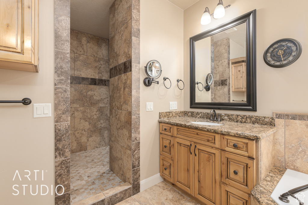 Bathroom with vanity, a tile shower, and tile flooring