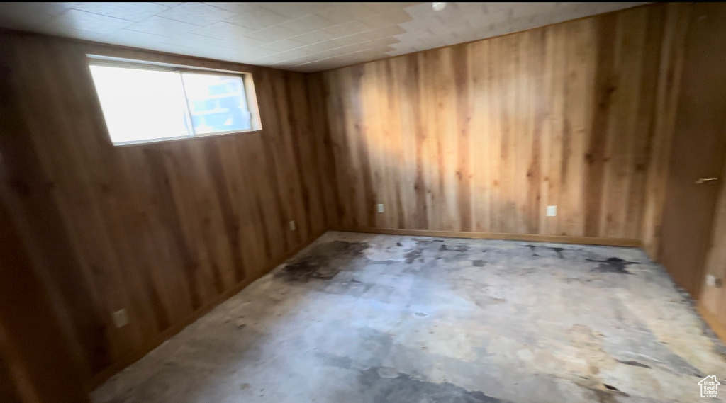 Unfurnished room featuring wooden walls