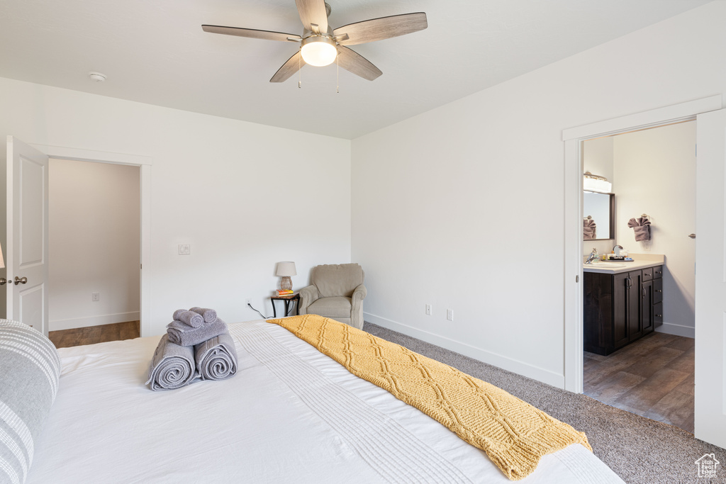 Bedroom featuring ensuite bath, dark wood-type flooring, and ceiling fan