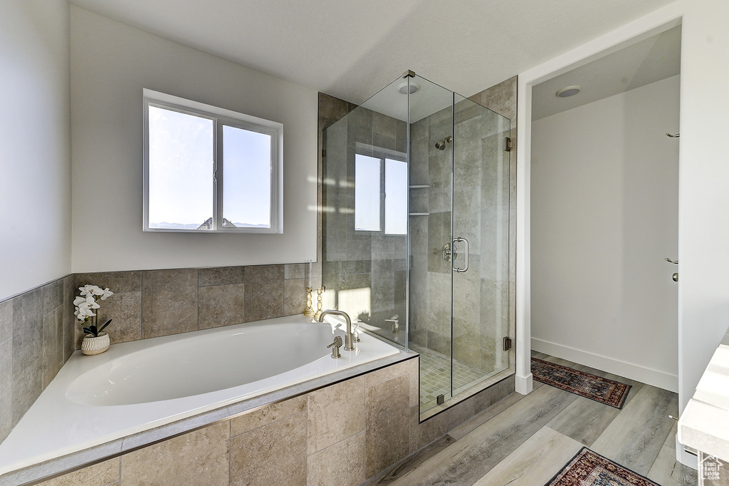 Bathroom with wood-type flooring and independent shower and bath