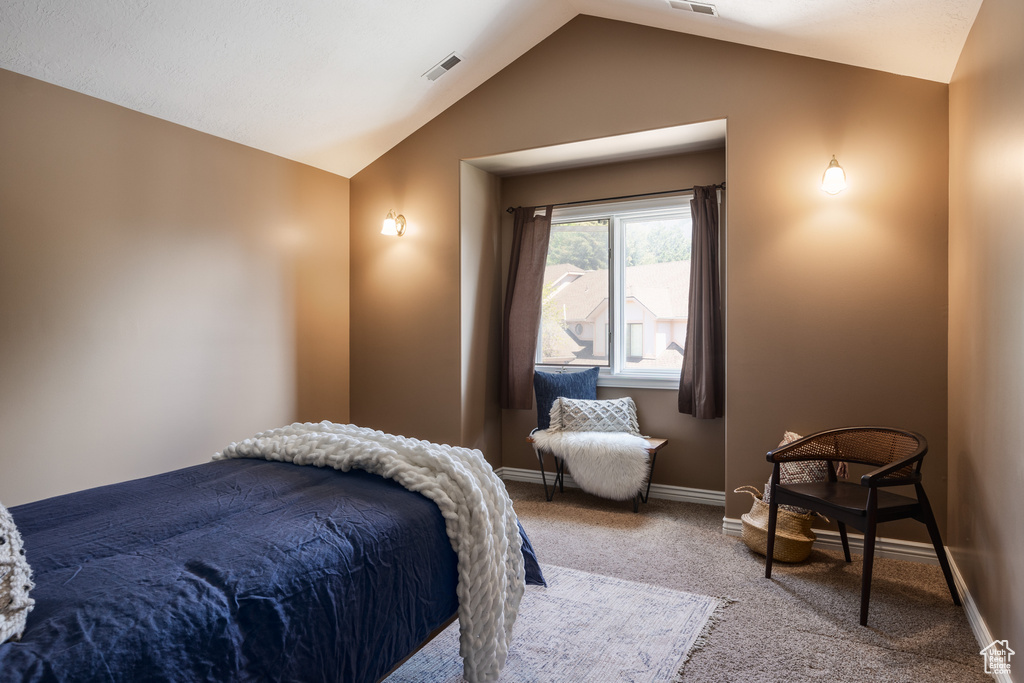 Carpeted bedroom featuring lofted ceiling