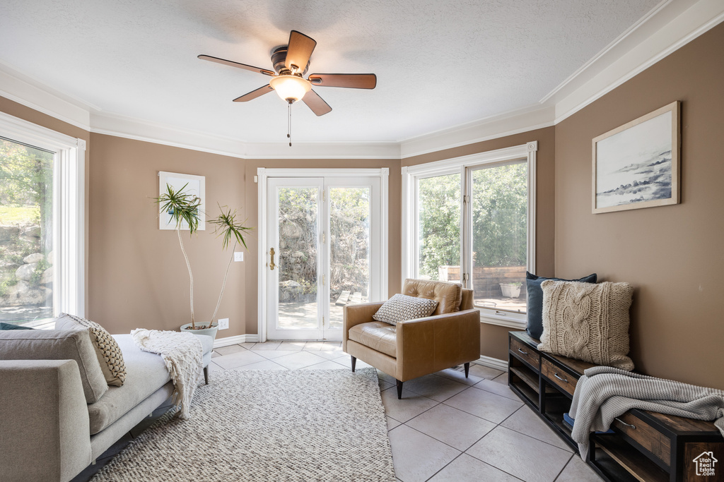 Tiled living room featuring ceiling fan and crown molding