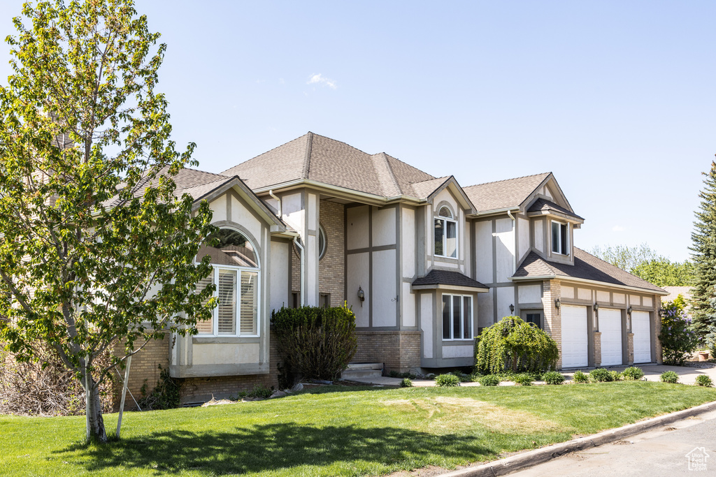 English style home with a front yard and a garage