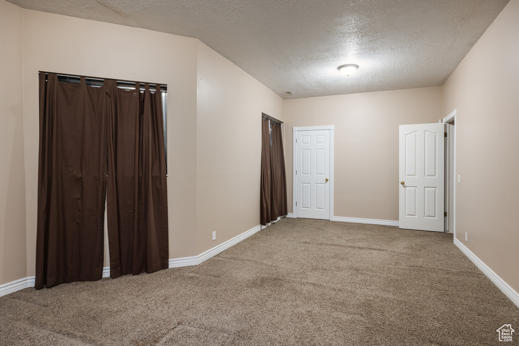 Unfurnished bedroom featuring carpet and a textured ceiling