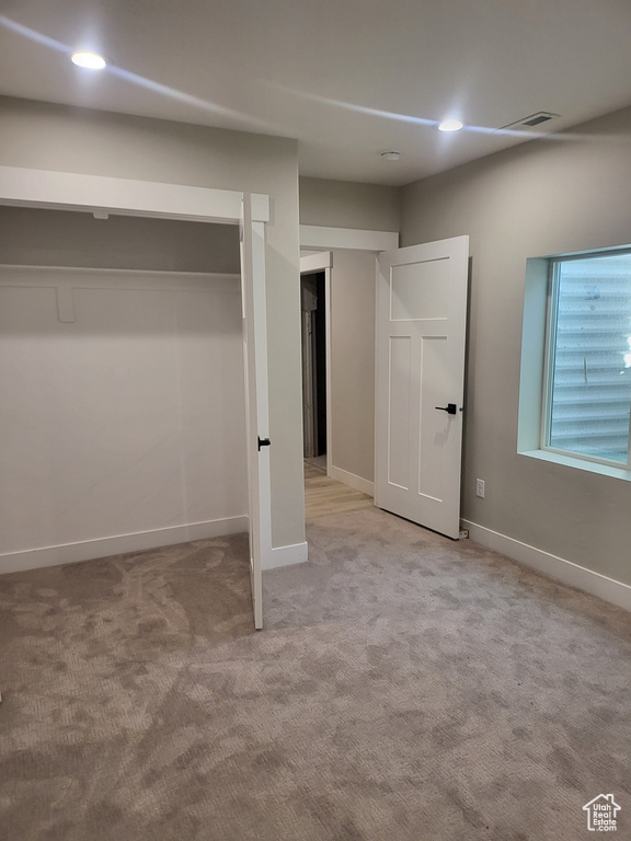 Unfurnished bedroom featuring light colored carpet