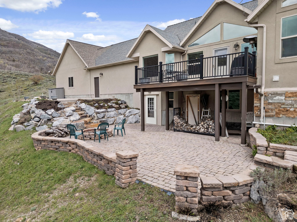 Back of property featuring a patio area, an outdoor fire pit, and a mountain view