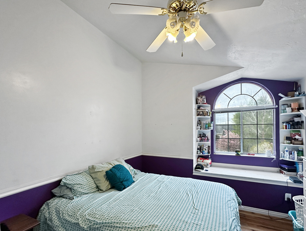 Bedroom with vaulted ceiling, ceiling fan, and wood-type flooring