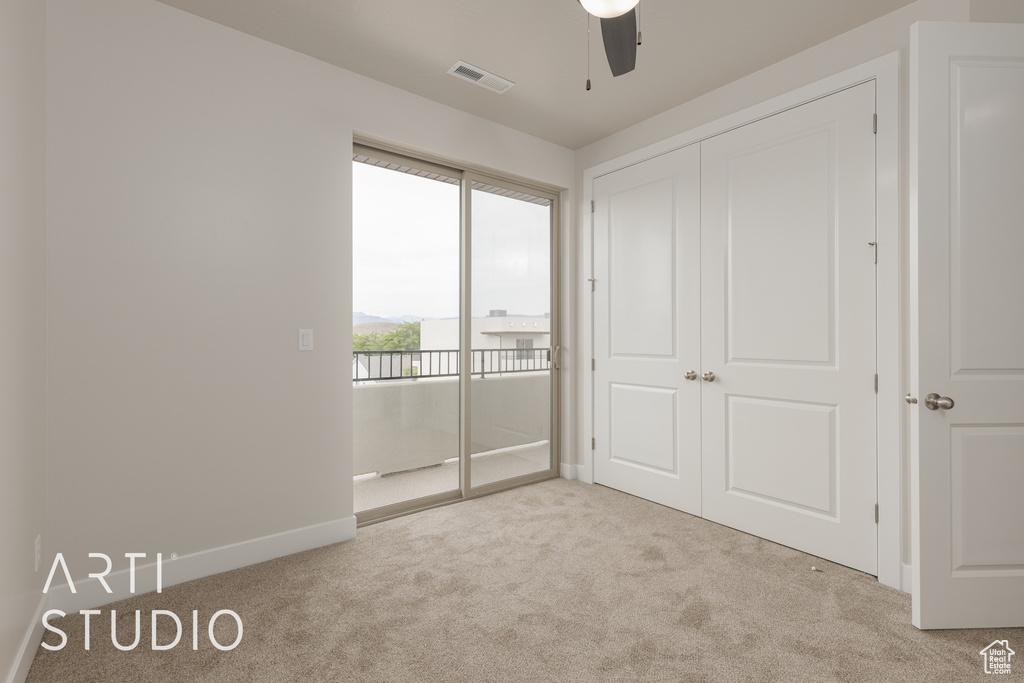 Unfurnished bedroom with ceiling fan, a closet, and light colored carpet