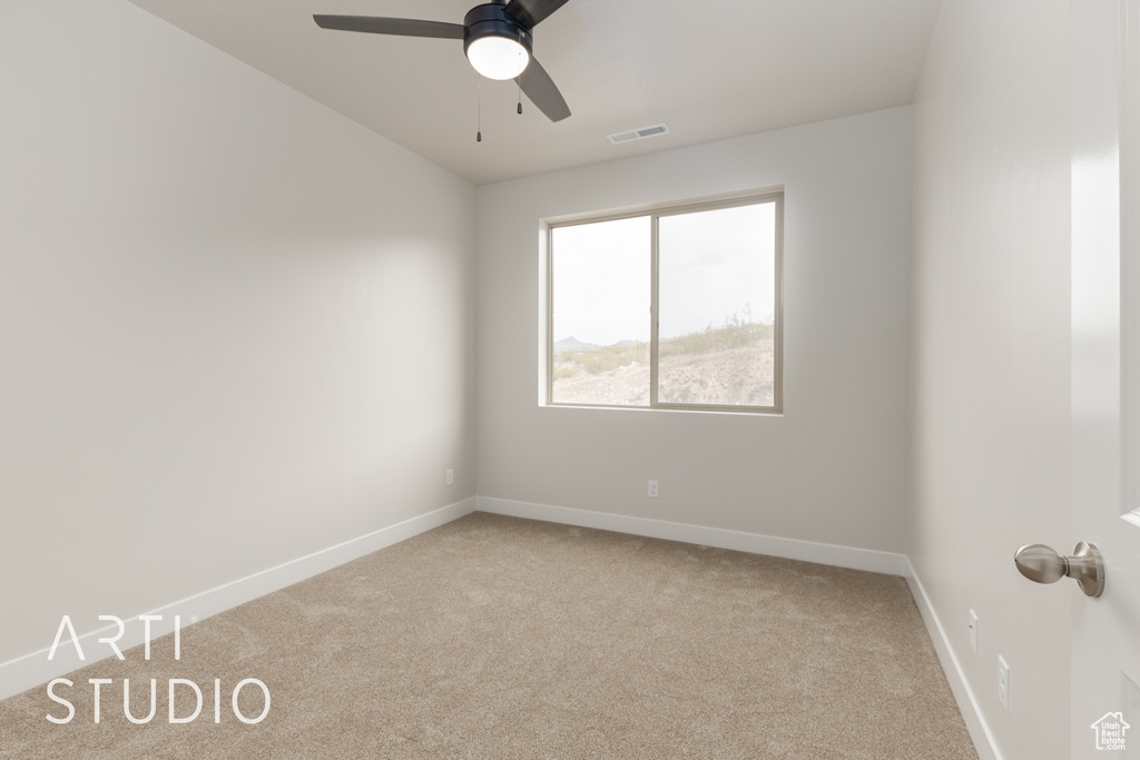 Carpeted spare room featuring ceiling fan