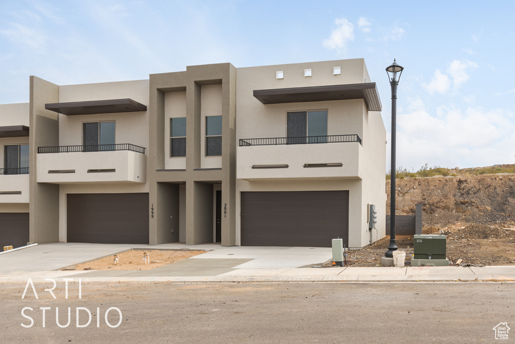 View of front of house with a garage and a balcony